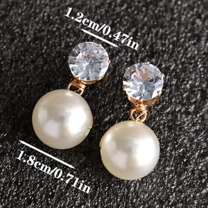 Detailweergave van bruidsoorbellen met 1,2 cm kristallen en 1,8 cm witte imitatieparels