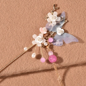 Horquilla dorada elegante con alas de organza, flores blancas, perlas y borlas largas
