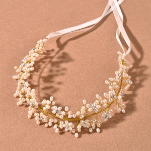 Detail of handmade bridal headband with pearls, crystals, and white satin ribbons