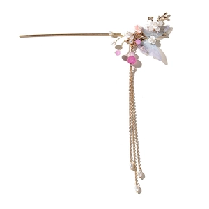Elegante horquilla dorada con alas de mariposa azules, flores y borlas largas de perlas
