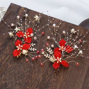 Elegant Chinese bridal red flower hair clips with golden accents and pearls on wood base
