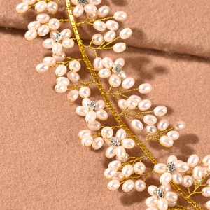 Macro shot of handmade bridal headband with pearls, crystals and golden woven wire