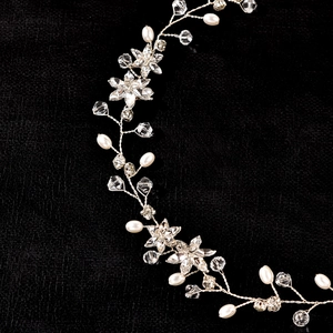 Détail d'une vigne à cheveux argentée pour mariée avec perles, cristaux et strass