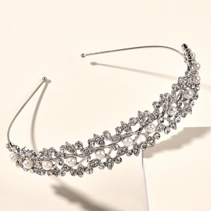 Détail de la couronne de mariée argentée avec feuilles ajourées, strass et perles blanches