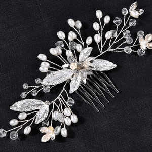 Détail d'un peigne à cheveux de mariée fait main avec feuilles argentées, perles et cristaux