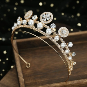 Luxury bridal crown with white pearls and zircons on gold metal, wedding accessory