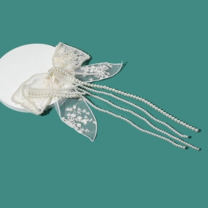 Pince à cheveux de mariée en dentelle blanche avec franges en perles sur fond turquoise