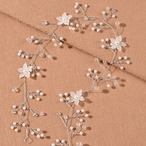 Macro detail of handmade bridal hair vine with pearls, crystals, and frosted flowers