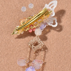 Ancient style gold butterfly hair clip with floral details and long purple tassels