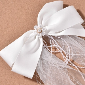Elegant white satin bow hair accessory with pearl flower and mesh veil for brides