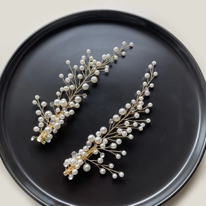 Barrettes de mariée dorées avec perles et strass sur fond noir élégant