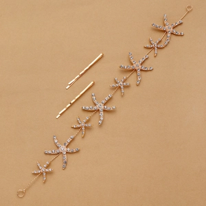 Close-up of golden starfish hair chain with white rhinestones and matching hair pins