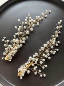 Détail des barrettes de mariage faites main avec perles et cristaux sur fil métallique doré
