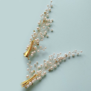 Détails de deux barrettes de mariée dorées faites main avec perles et motif de feuilles