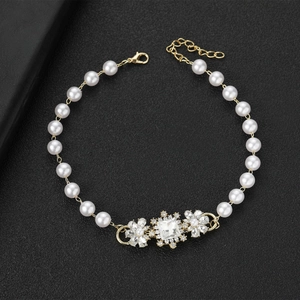 Détail macro du bracelet perles avec motif floral en strass et fermoir doré ajustable