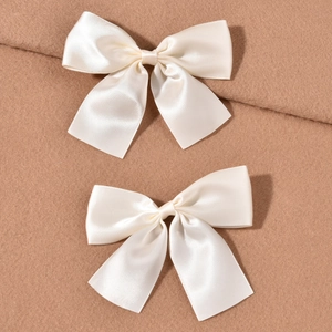 Set of two creamy white satin bow hair clips for elegant bridal wedding hair accessories