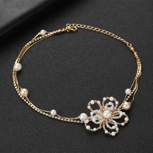 Vue détaillée du collier de perles avec nœud et cristaux sur un fond noir luxueux