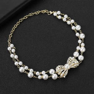 Collier de perles à deux rangs avec pendentif nœud en strass sur un fond noir élégant