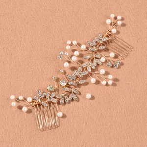 Détail d'un peigne à cheveux de mariée avec fleurs argentées, perles et strass brillants