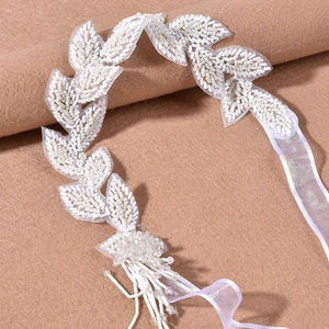Handmade bridal headband with beaded leaves and tassel details on white ribbon tie