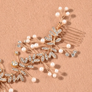 Vue macro du peigne à cheveux de mariée doré avec perles et détails de fleurs strass