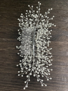 Détail d'un peigne à cheveux de mariée avec perles blanches et branches en fil argenté