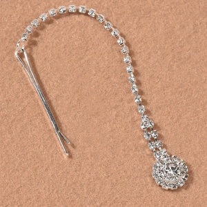 Detailed macro view of silver rhinestone fringe hairpiece with sparkling diamond pendant