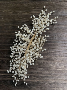 Détail d'un peigne à cheveux de mariée avec fil doré et perles blanches élégantes