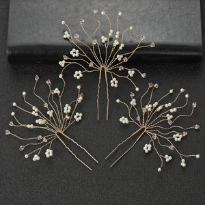 Three bridal U-shaped hair pins with pink crystals and pearls on black background