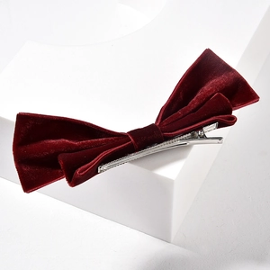 Barrette à cheveux élégante en velours bordeaux avec texture vintage sur socle blanc