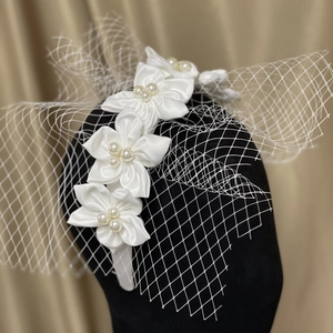 Elegant white satin flower bridal headband with pearls and delicate mesh birdcage veil