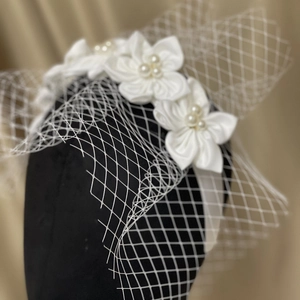Elegant white satin flower headband with pearls and mesh veil for bridal wedding hair