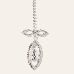 Detailed macro view of silver rhinestone forehead jewelry with bow and marquise drop