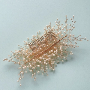 Détail du peigne à cheveux doré avec perles blanches pour coiffure de mariée élégante