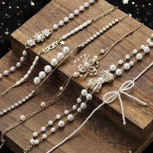 Vue détaillée de colliers de perles et bracelets Lucky sur fond de bois sombre élégant