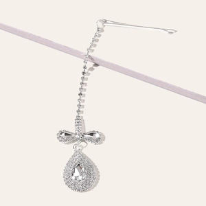 Detail of silver tassel hair jewelry with rhinestone bow and waterdrop pendant