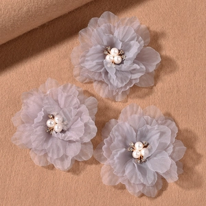 Macro shot of three purple organza flower hair clips with faux pearls and rhinestones