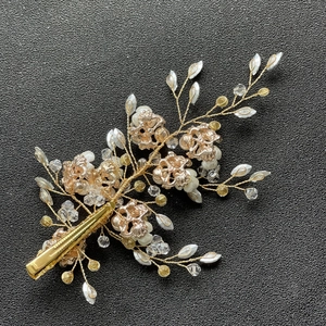 Détail d'une pince à cheveux de mariée faite main avec fil doré, perles et cristaux
