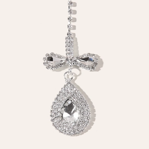 Close-up of silver rhinestone forehead jewelry with bow and pear-shaped drop pendant