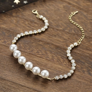 Détail d'un collier de perles dorées élégant avec cristaux sur fond en bois sombre