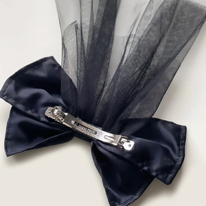 Elegant black satin bow hair clip with sheer mesh veil on a clean white background