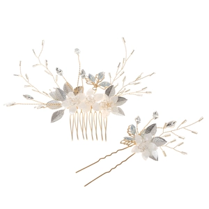 Dettaglio del pettine e forcina da sposa con fiori bianchi e foglie argentate