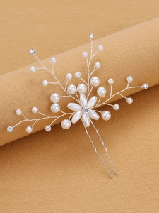 Detailed close-up of handmade bridal hair pin with pearls and rhinestones on silver wire