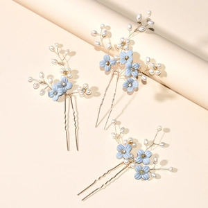 Detailed view of handmade light blue floral hair pins with white pearls and crystals