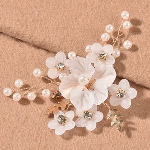 Fermaglio sposa con fiori bianchi, foglie dorate e perle su sfondo in tessuto cammello