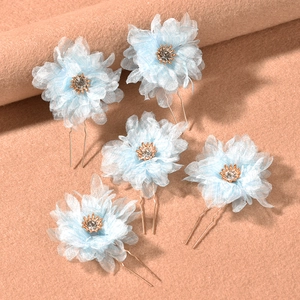 Set of 5 light blue organza flower hair pins with crystals on a textured background