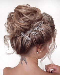 Detail of a bridal hair vine with marquise crystals and silver wire on a neat hair bun
