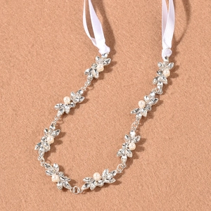Vigne de cheveux de mariée argentée avec perles blanches et cristaux sur fond beige