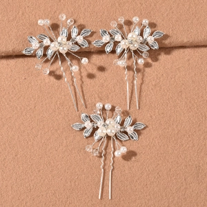 Detailed close-up of bridal hair pins set featuring silver leaves and pearls