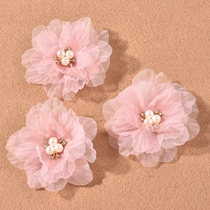 Detailed macro view of three layered pink mesh flower hair clips with pearl centers